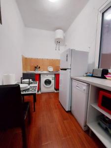 a small kitchen with a white refrigerator and a table at Casa Rebeca in Teror