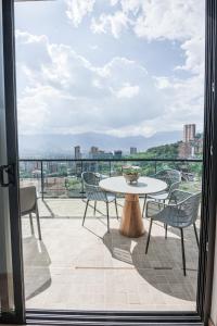 a patio with a table and chairs on a balcony at Be Mate Medellín in Medellín