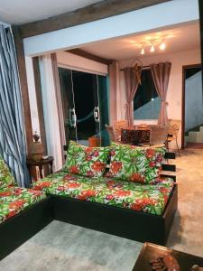 un soggiorno con divano e alcune finestre di O mais lindo pôr do sol ad Arraial do Cabo