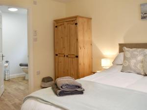 a bedroom with a bed and a wooden cabinet at Drake Lodge in Staithes