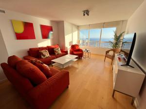 a living room with a red couch and a television at Apartamento Beach & Chic Cabo Huertas in Alicante