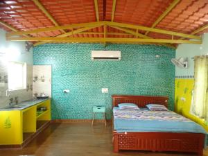 a bedroom with a bed in a room with green walls at MangoHut Farmhouse Pool Villa in Hyderabad