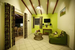 - un salon avec des murs verts et un canapé vert dans l'établissement La Palmeraie Dorée, à Saint-François