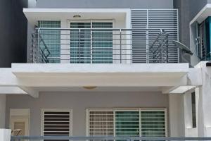 Cette maison blanche dispose d'un balcon. dans l'établissement Muslim Homestay ArRayyan, à Port Dickson