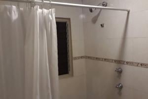 a bathroom with a shower with a white shower curtain at Casa Ejecutivo Zona Iteso Bahía de Acapulco in Guadalajara