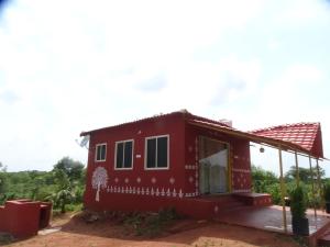 a red house with white designs on it at MangoHut Farmhouse Pool Villa in Hyderabad