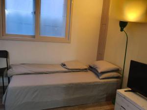 1 dormitorio con 2 camas y ventana en Dalseogu Resting Place, en Daegu