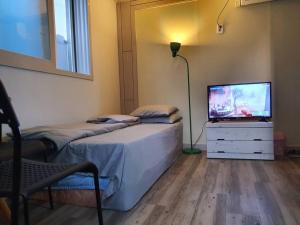 a bedroom with two twin beds and a television at Dalseogu Resting Place in Daegu