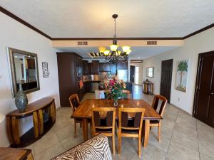 a kitchen and dining room with a wooden table and chairs at Sonoran Sky in Puerto Peñasco