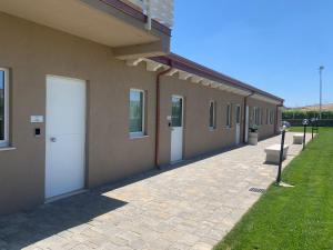 a building with two white doors and a sidewalk at Masseria Spinale Wine Resort in Melfi