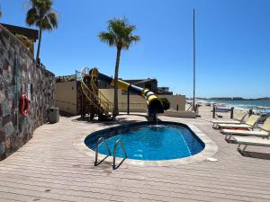 a pool with a slide in the middle of a beach at Sonoran Sky in Puerto Peñasco