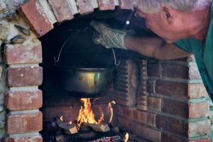 a man is putting a pot in a brick oven at Penzion pod Stráni in Malá Morávka