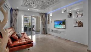 ein Wohnzimmer mit Sofa und Fernseher in der Unterkunft Luxury House Paraiso Del Palm Mar in Palm-mar