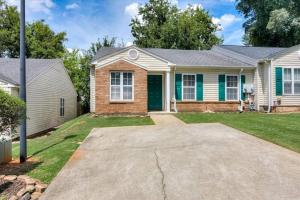 uma casa com uma porta verde em The Masters Cottage by Augusta National em Augusta