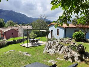 a garden with a table and a house at La Huerta, megustarural in Llanes