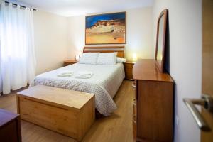 a small bedroom with a bed and a dresser at La Huerta, megustarural in Llanes