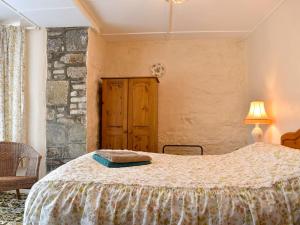 a bedroom with a bed and a stone wall at Lower Chinkwell-uk12426 in Widecombe in the Moor