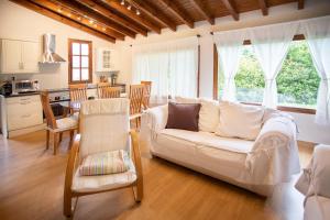 a living room with a white couch and a kitchen at La Huerta, megustarural in Llanes