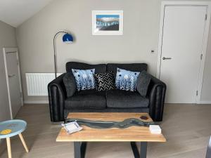a living room with a black couch and a coffee table at River Vista Retreat - Luxury duplex Apt - Views - Parking - Cycle storage - Spa access option in Backbarrow