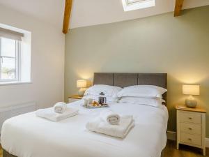 a bedroom with a large white bed with towels on it at Cor Tarw - Uk12743 in Acrefair