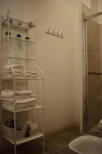 a bathroom with a rack of towels and a shower at Beans Street Affittacamere in Mola di Bari