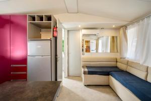 een kleine kamer met een bed en een koelkast bij Camping Grande Italia Belvedere in Chioggia
