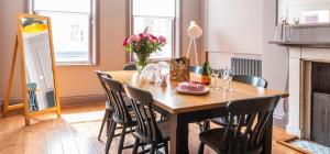 The Lawrance Luxury Aparthotel - York في يورك: غرفة طعام مع طاولة وكراسي خشبية