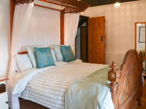 a bedroom with a large bed with blue pillows at Meadwell in Treknow