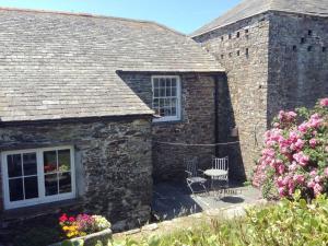 a stone house with two chairs and a window at Meadwell in Treknow