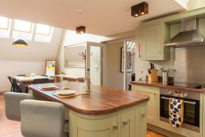 cocina con armarios verdes y encimera de madera en The Lawrance Luxury Aparthotel - York, en York
