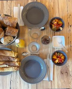 una mesa de madera con platos de comida y pan en La Villa des Sables, en Concarneau
