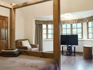 a bedroom with a bed and a tv and a couch at Springfields in Leek