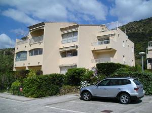 ル・ラヴァンドゥーにあるLe Lavandou St Clairの建物の前の駐車場に駐車された車