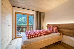 a bedroom with a bed with red and white pillows at Lagar Apartement Pircher Schnallele in San Leonardo in Passiria