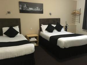 a hotel room with two beds with black and white pillows at Lord Nelson Hotel in Liverpool