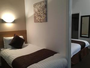 a hotel room with two beds and a mirror at Lord Nelson Hotel in Liverpool