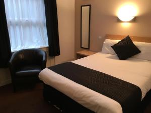 a hotel room with a bed and a chair at Lord Nelson Hotel in Liverpool