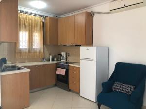 a kitchen with a white refrigerator and a blue chair at Artemis House in Artemida