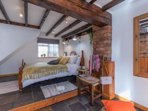 a bedroom with a bed and a brick wall at The Old Rope Works in Bewdley