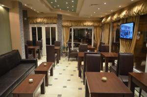 un restaurante con mesas, sillas y TV en Garni Hotel Lion en Jagodina