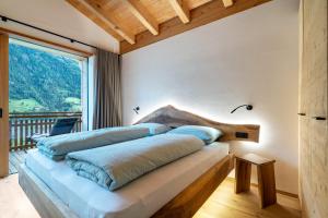 un letto in una camera con una grande finestra di Lagar Apartement Struzer Michele a San Leonardo in Passiria