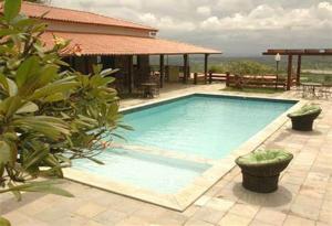 a large swimming pool in front of a house at Flat Studio 11 Condomínio Monte Castelo em Hotel Fazenda Gravatá-PE in Gravatá