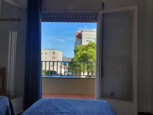 a bedroom with a window with a view of a city at Payet Apartments in L'Estartit