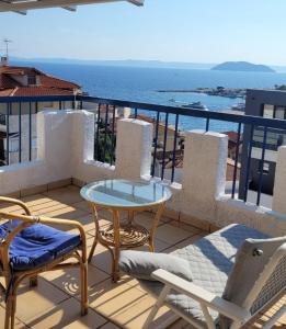 a balcony with a table and chairs and the ocean at Egeon Studios in Neos Marmaras