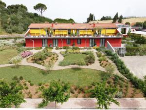 een rood huis met een tuin ervoor bij Bocelli Guest House in Laiatico