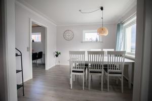 a dining room with a white table and chairs at Jotunheim / Aparthotel / Family Friendly in Miðvágur