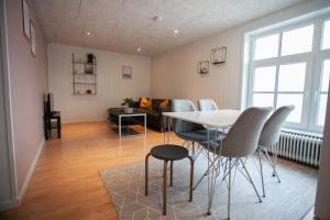 a living room with a table and chairs and a couch at Jotunheim / Aparthotel / Family Friendly in Miðvágur