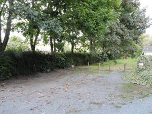 una strada sterrata con alberi e una casa sullo sfondo di La Bouee, entre Manche et Seine a Saint-Nicolas-de-la-Haie