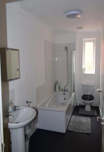 łazienka z wanną, umywalką i toaletą w obiekcie Beach escape 4 bedroom house, Sleeps 11, 2 free parking, garden, WIFI, Smart TV, newly decorated w Bournemouth