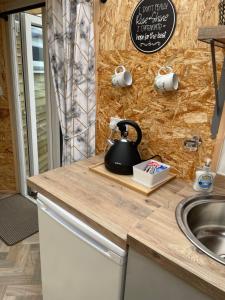 a kitchen with a sink and a tea kettle on a counter at Pen-Y-Bryn Annex in Brynmenyn
